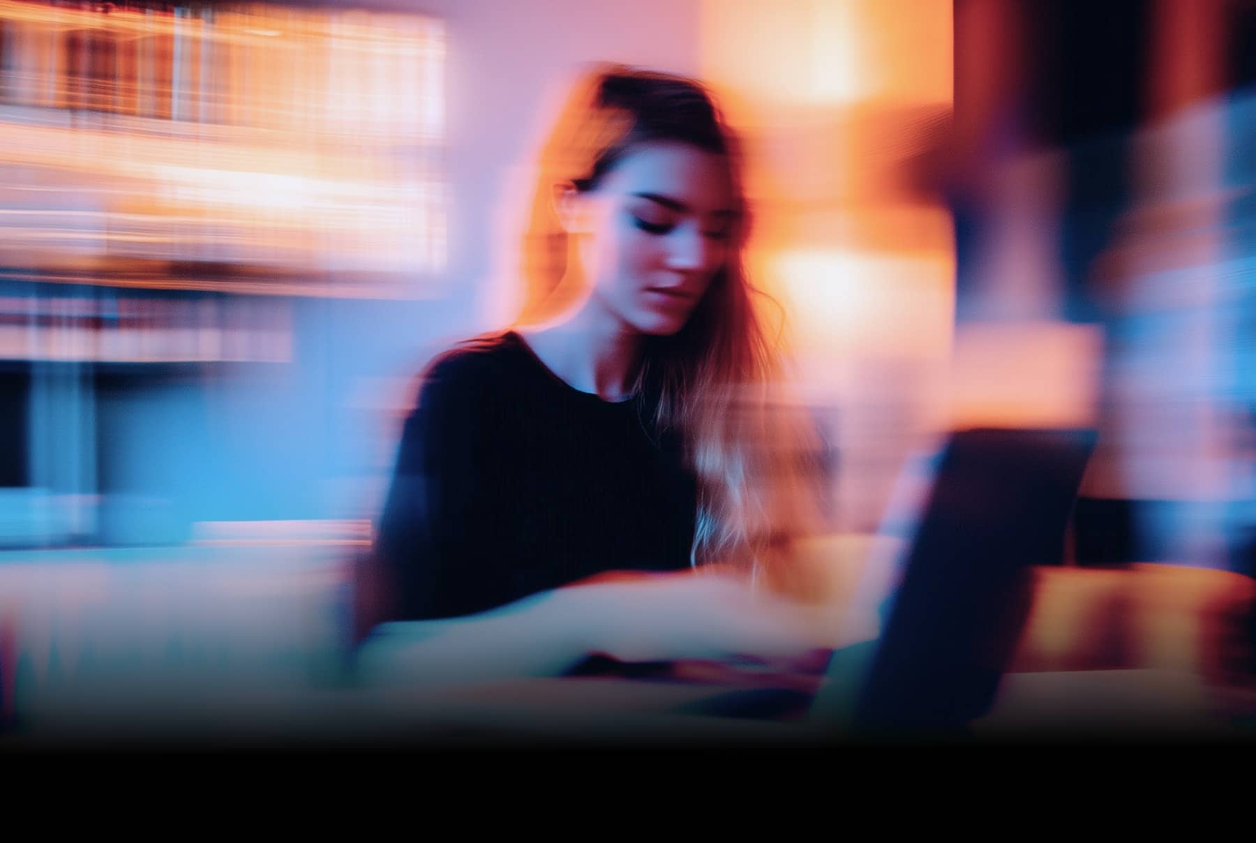Imagen de mujer desenfocada con un ordenador portátil